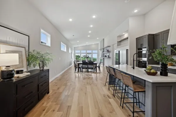 a living room with furniture large wooden floor and large windows