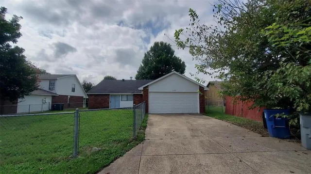 a view of a front of house with a yard and large tree