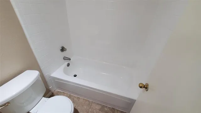 a bathroom with a bathtub and toilet