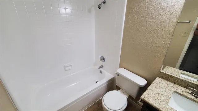 a white toilet sitting next to a bath tub