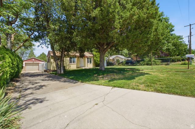 94 West 2000th Street North Clearfield, UT 84015 - Photo 17 of 26 Wide exterior view featuring mature trees, long driveway, detached garage, and spacious front yard with established landscaping.
