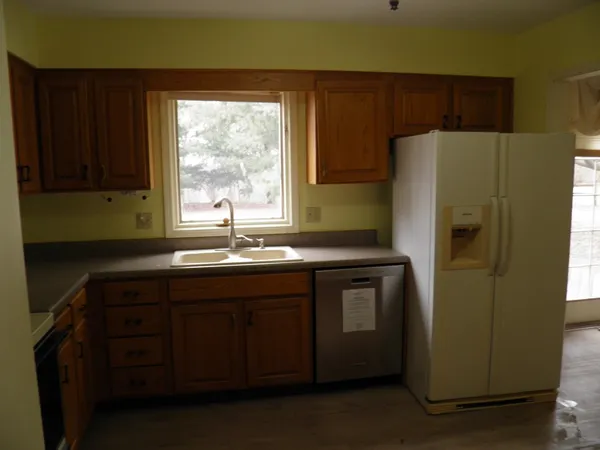 a kitchen with stainless steel appliances granite countertop a refrigerator and a sink