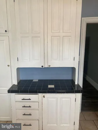 a kitchen with a white cabinets and black appliances