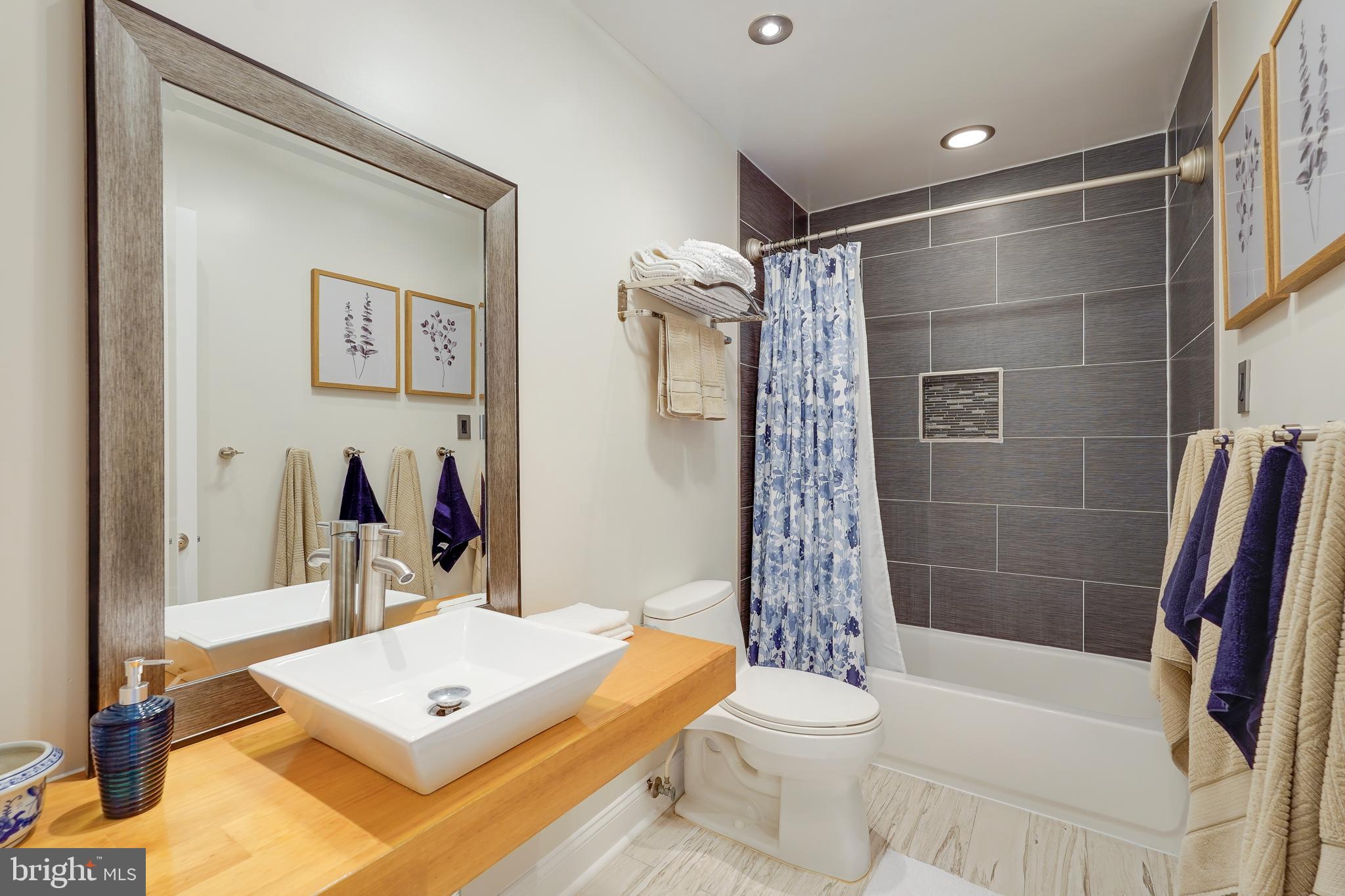 701 Stratford Manor Terrace Silver Spring, MD 20905 - Photo 30 of 43 a bathroom with a sink a toilet a mirror and shower