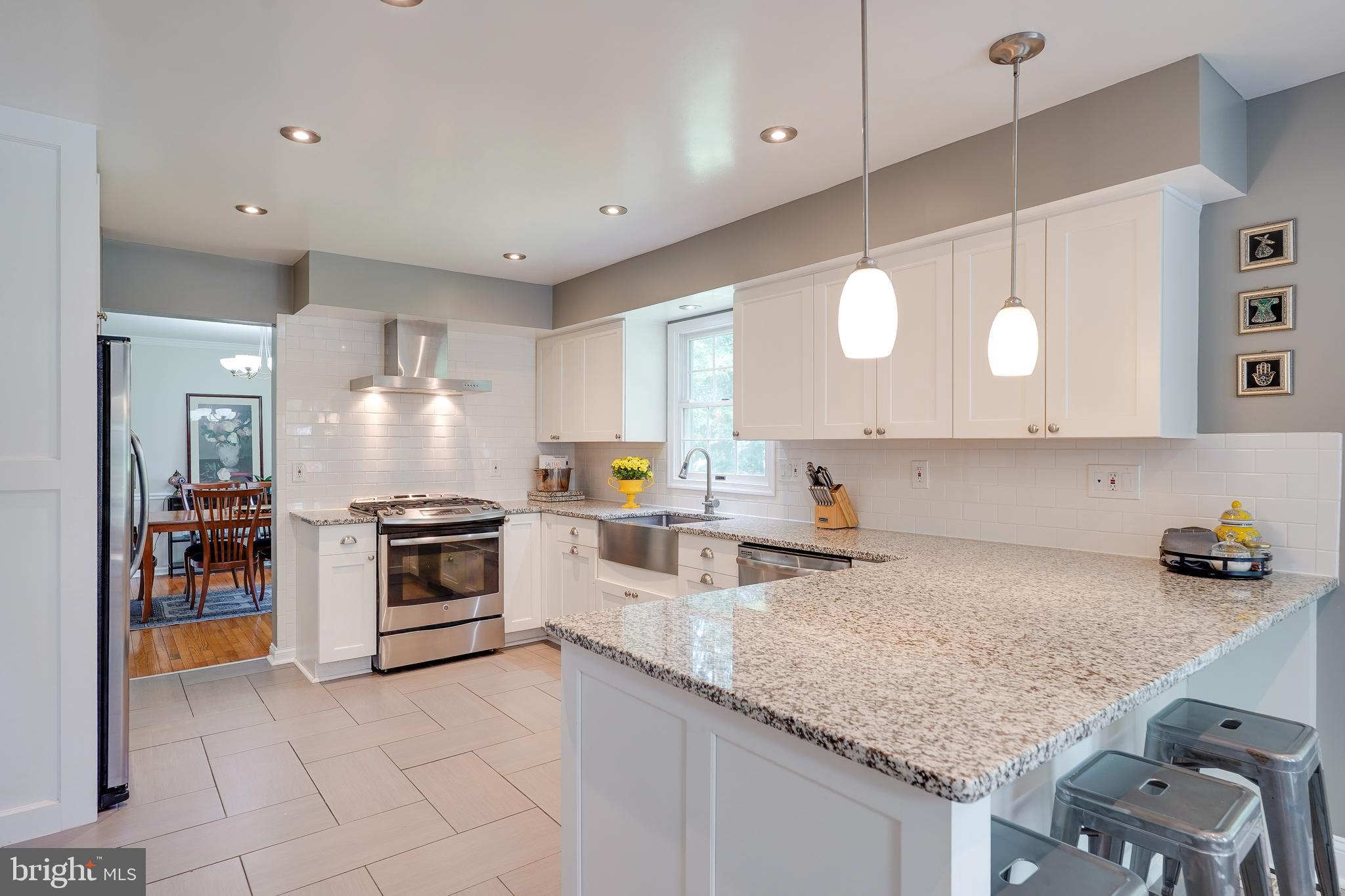 701 Stratford Manor Terrace Silver Spring, MD 20905 - Photo 10 of 43 a kitchen with granite countertop a stove oven and sink