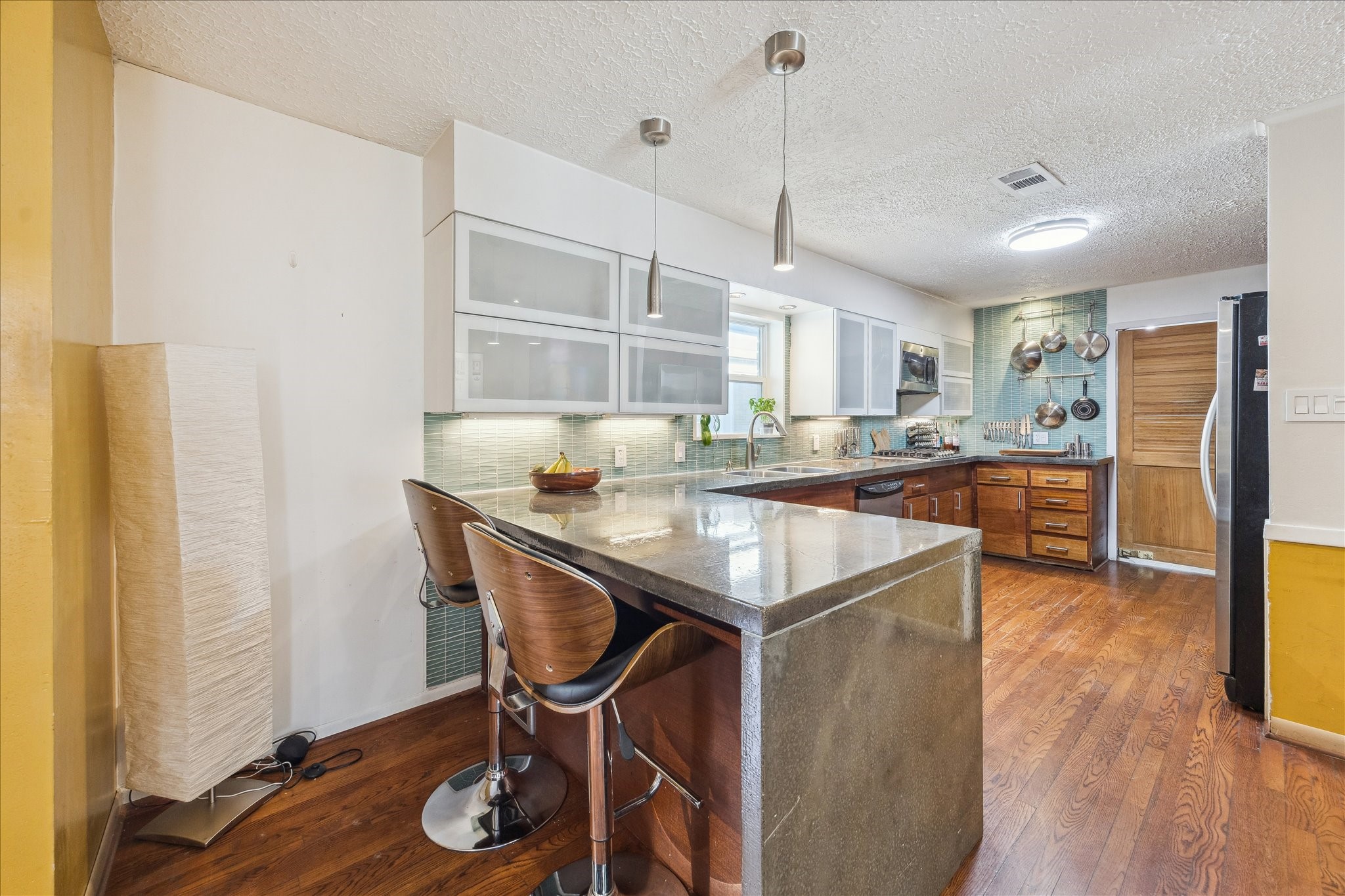 10102 Knoboak Drive Houston, TX 77080 - Photo 15 of 39 a kitchen with granite countertop a table chairs refrigerator and wooden floor