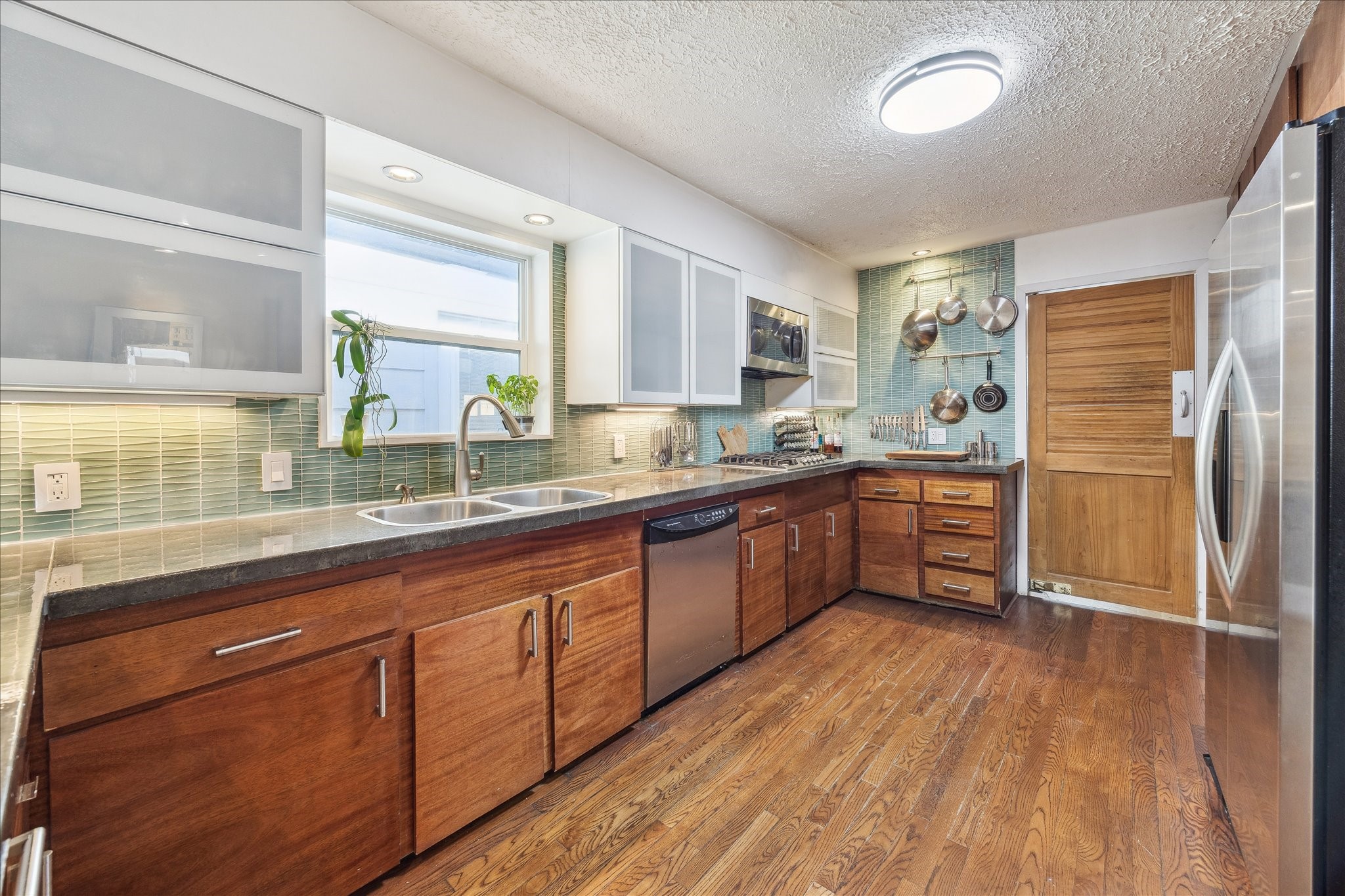 10102 Knoboak Drive Houston, TX 77080 - Photo 18 of 39 a kitchen with stainless steel appliances granite countertop a sink cabinets and wooden floor