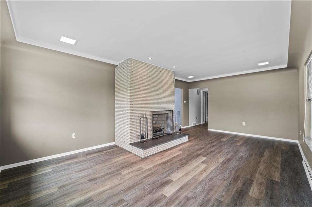 207 Ridge Avenue Freedom, PA 15042 - Photo 10 of 49 an empty room with wooden floor fireplace and windows