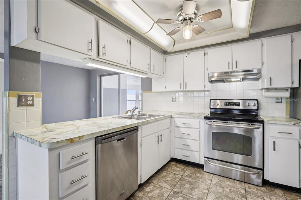 3548 Darlington Road Holiday, FL 34691 - Photo 13 of 32 a kitchen with granite countertop a sink stainless steel appliances and cabinets
