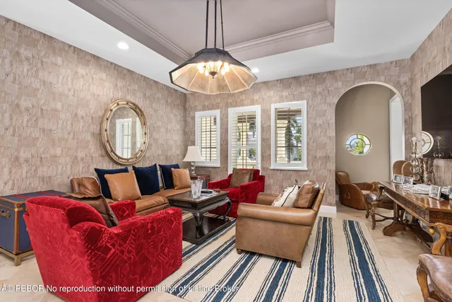 a living room with furniture a fireplace and a chandelier