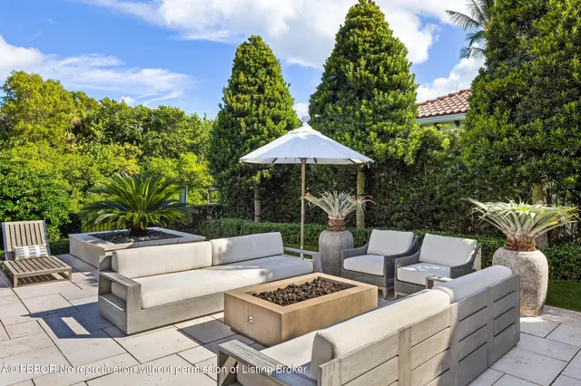 a view of a patio with furniture and a garden