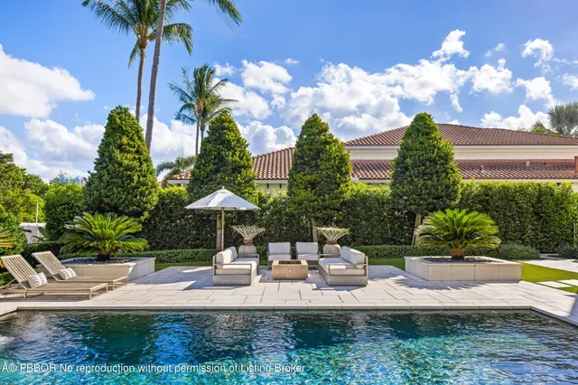 a swimming pool with outdoor seating and garden