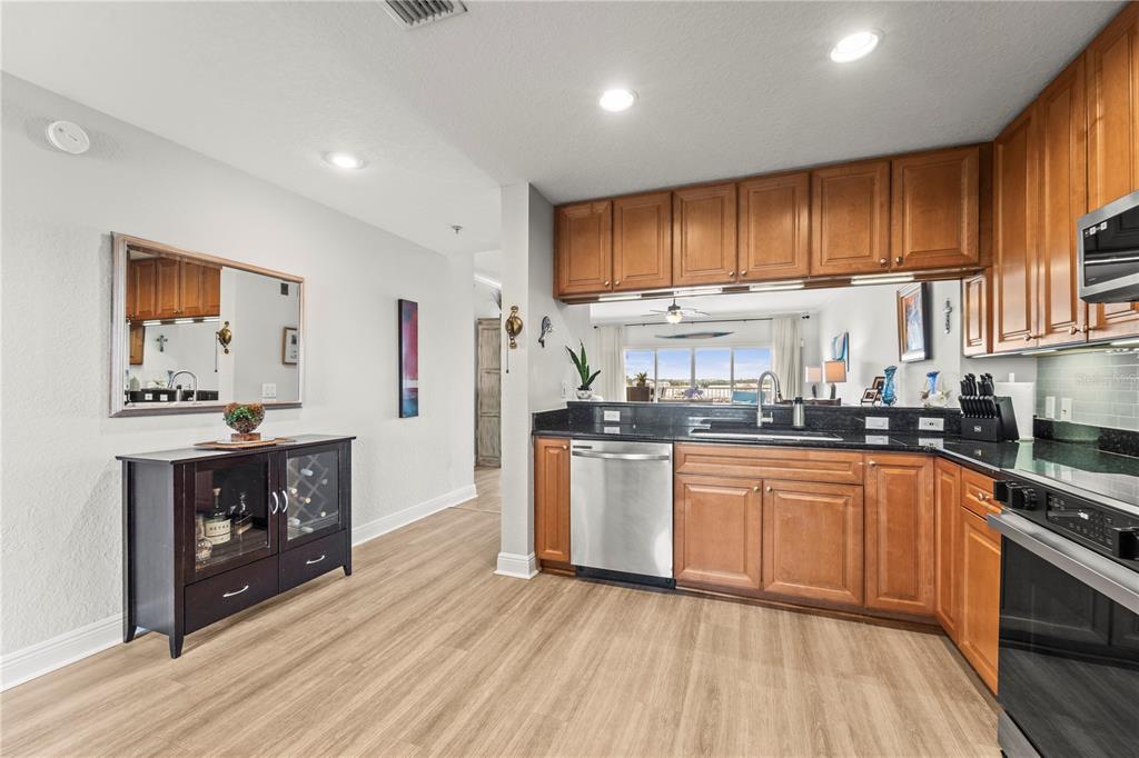 425 150th Avenue, Unit 2303 Madeira Beach, FL 33708 - Photo 11 of 69 a kitchen with stainless steel appliances granite countertop a stove cabinets and wooden floor