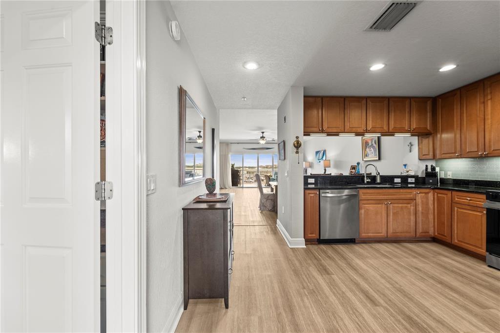 425 150th Avenue, Unit 2303 Madeira Beach, FL 33708 - Photo 12 of 69 a kitchen with stainless steel appliances granite countertop a refrigerator a sink dishwasher a stove and white countertops with wooden floor