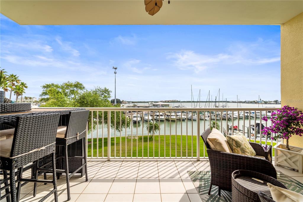 425 150th Avenue, Unit 2303 Madeira Beach, FL 33708 - Photo 22 of 69 a view of a balcony with wooden floor and outdoor seating
