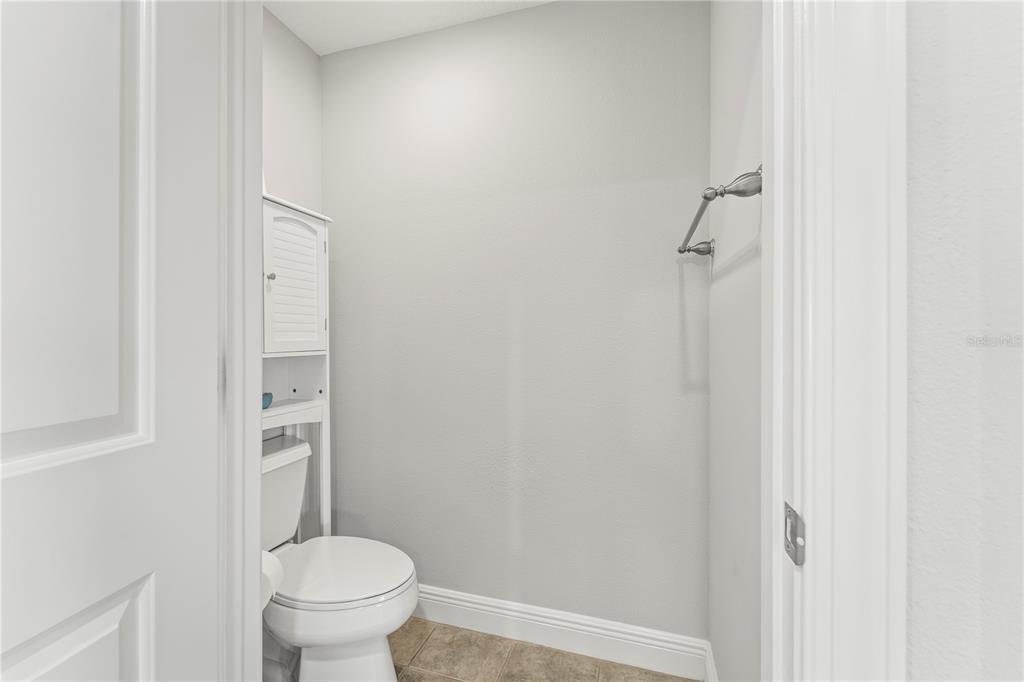 425 150th Avenue, Unit 2303 Madeira Beach, FL 33708 - Photo 37 of 69 a bathroom with a granite countertop toilet and a shower