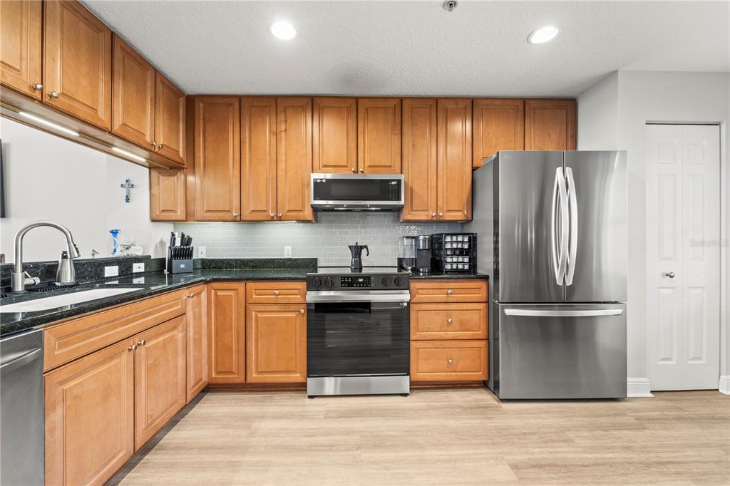 425 150th Avenue, Unit 2303 Madeira Beach, FL 33708 - Photo 5 of 69 a kitchen with stainless steel appliances granite countertop a refrigerator stove and sink