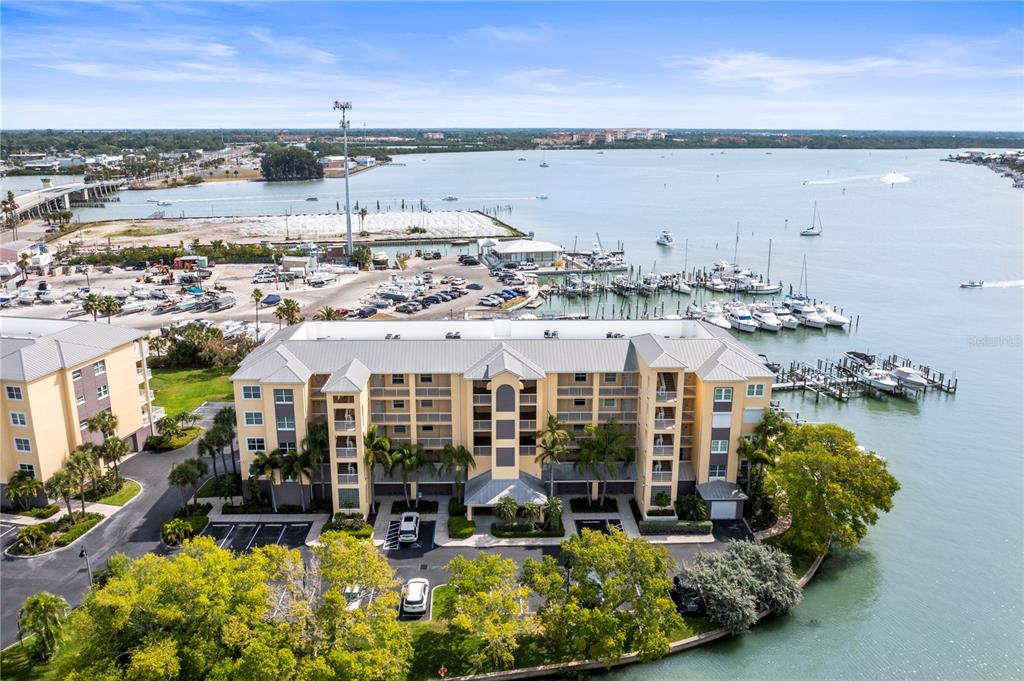 425 150th Avenue, Unit 2303 Madeira Beach, FL 33708 - Photo 65 of 69 a view of a lake with a building and trees in the background