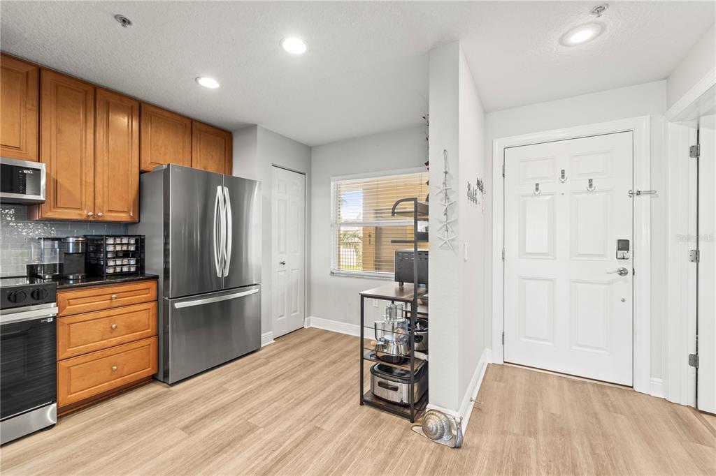 425 150th Avenue, Unit 2303 Madeira Beach, FL 33708 - Photo 7 of 69 a kitchen with stainless steel appliances wooden floor and refrigerator