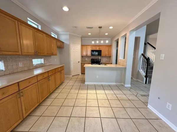 a large kitchen with stainless steel appliances a sink a counter top space cabinets and a window