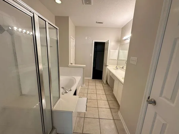 a bathroom with a tub sink and mirror