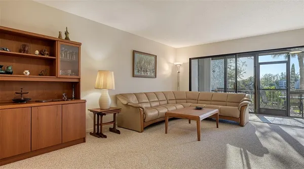 a living room with chairs and a floor to ceiling window