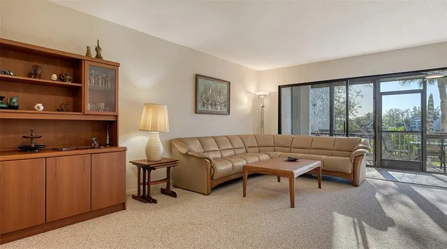 a living room with chairs and a floor to ceiling window
