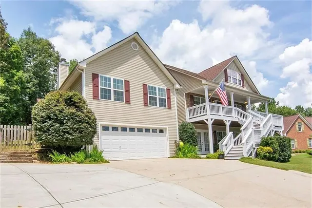 a view of a white house with large windows and a small yard