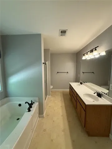 a bathroom with a tub sink and mirror