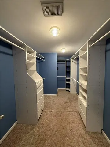 a view of walk in closet with empty racks