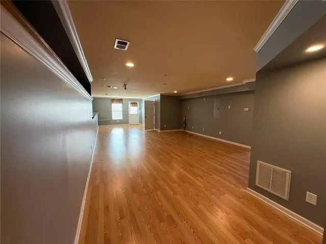 a view of empty room with wooden floor