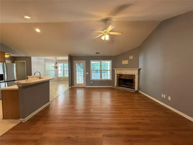 a view of empty room with wooden floor and fireplace