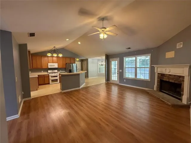 a view of a big room with wooden floor and a kitchen