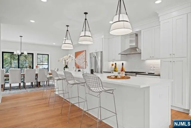 a kitchen with stainless steel appliances a stove a sink a center island and cabinets