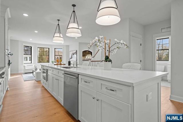 147 Central Avenue, Unit 20 Old Tappan, NJ 07675 - Photo 5 of 50 a large kitchen with kitchen island white cabinets and chandelier