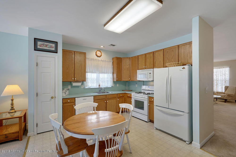 47 Wordsworth Road Brick, NJ 08724 - Photo 16 of 42 a kitchen with stainless steel appliances a refrigerator a stove a sink a dining table and chairs with wooden floor
