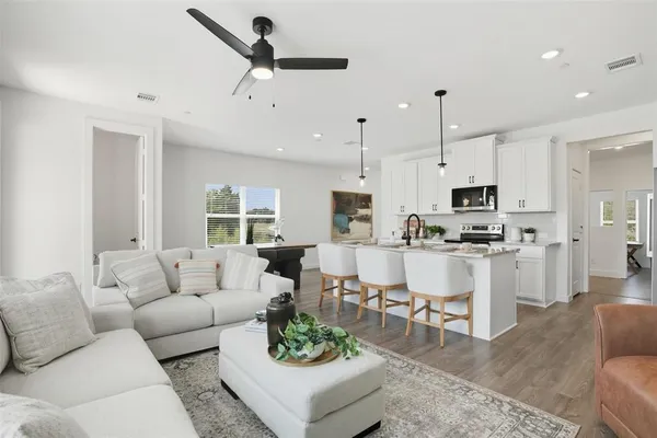 a living room with furniture kitchen area and a view of kitchen