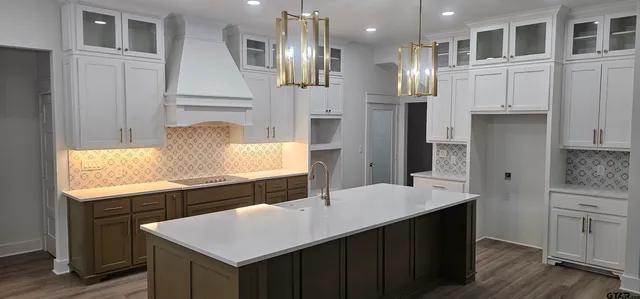 a kitchen with granite countertop a sink stainless steel appliances and cabinets