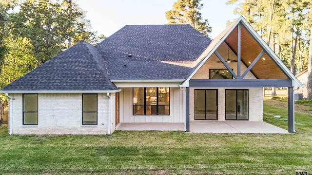 an aerial view of residential houses with outdoor space and trees