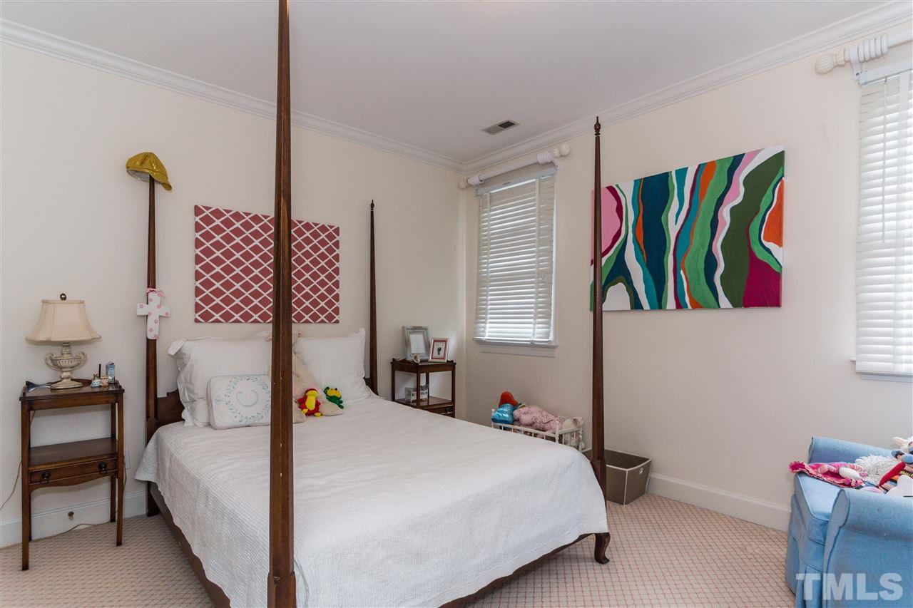 1712 Craig Street Raleigh, NC 27608 - Photo 15 of 25 a bedroom with a bed and a potted plant