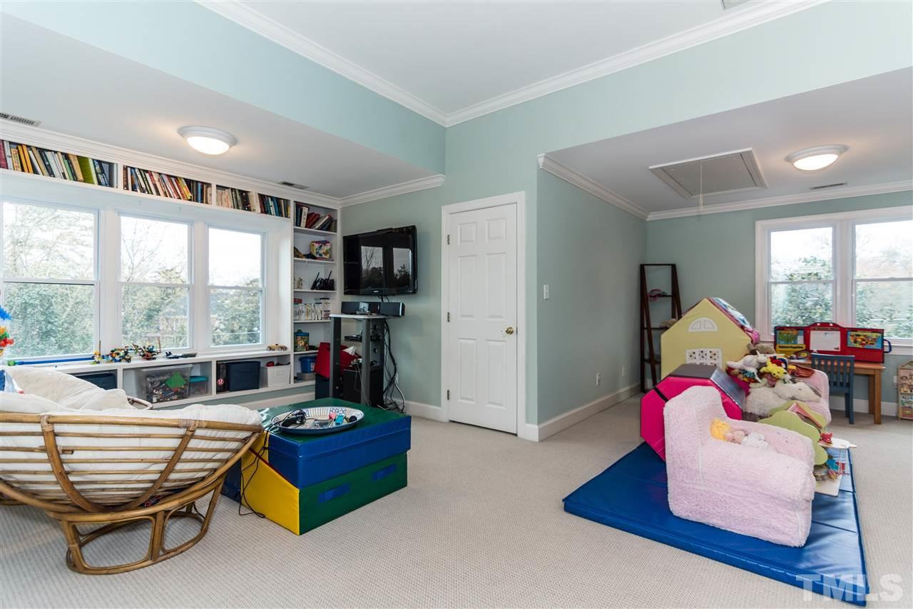 1712 Craig Street Raleigh, NC 27608 - Photo 20 of 25 a living room with furniture floor to ceiling window and a flat screen tv