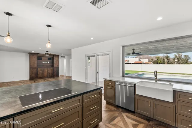 a view of a livingroom with a chandelier fan and windows