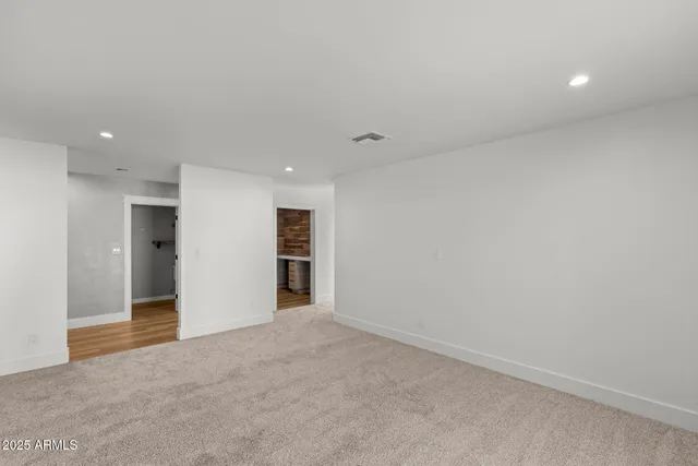 an empty room with a granite countertop double vanity and mirror