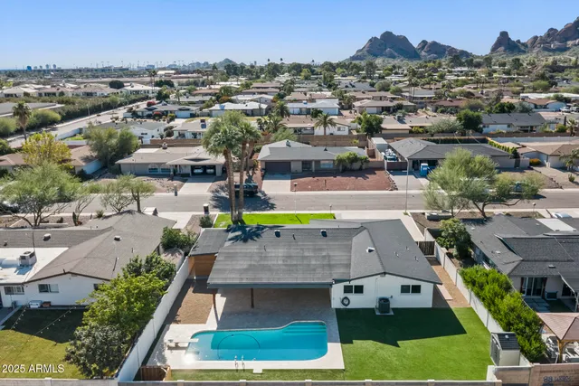 an aerial view of a house with a swimming pool yard and mountain view in back