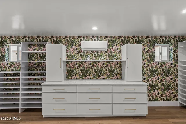 a view of an empty room with wooden cabinets