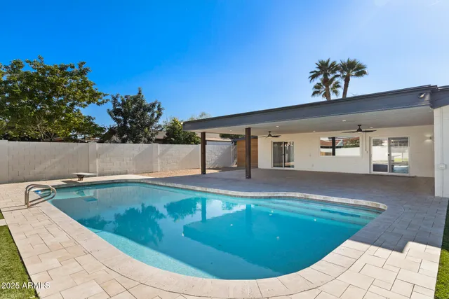 a view of a house with a patio and a yard