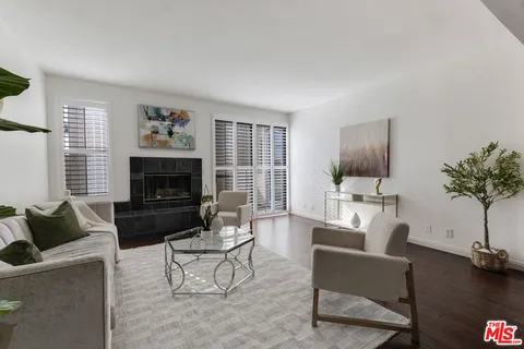 a living room with furniture a fireplace and a potted plant