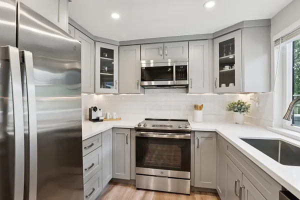 a kitchen with stainless steel appliances granite countertop a sink stove and refrigerator