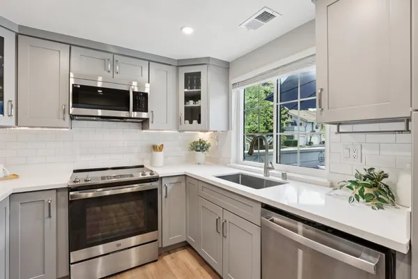 a kitchen with stainless steel appliances a stove microwave and sink
