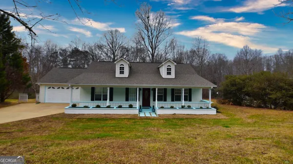 a front view of house with yard and trees in the background